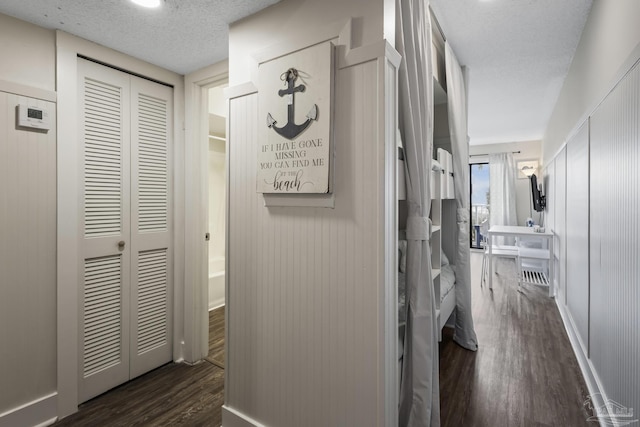 corridor featuring dark hardwood / wood-style floors and a textured ceiling