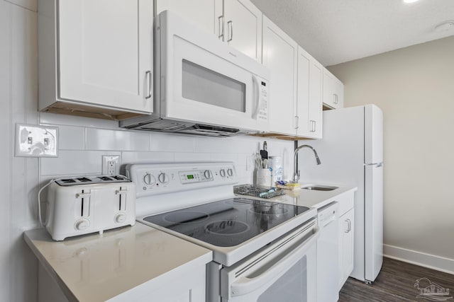 kitchen featuring backsplash, white appliances, sink, and white cabinets