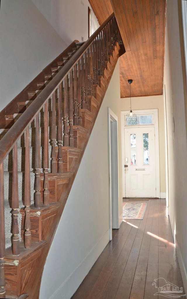 entryway with stairway, wood-type flooring, wood ceiling, and baseboards