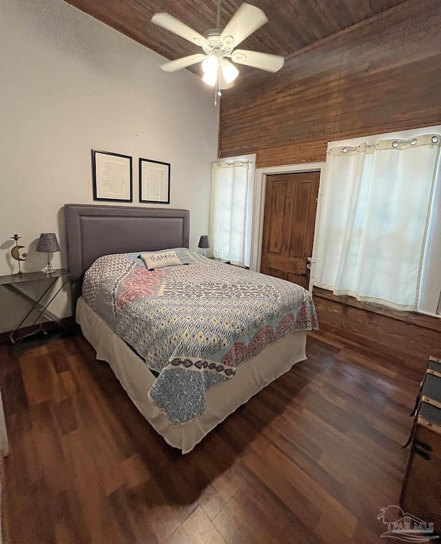 bedroom featuring ceiling fan, wood walls, and wood finished floors