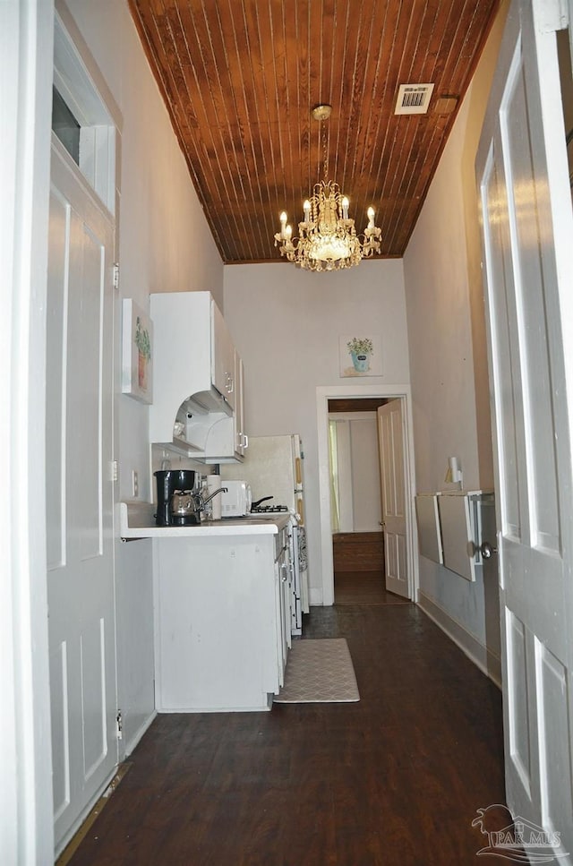 kitchen featuring a notable chandelier, wood ceiling, visible vents, white cabinets, and light countertops