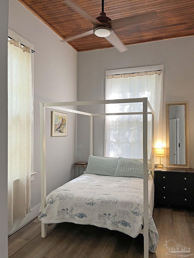 bedroom featuring ceiling fan, beamed ceiling, wood finished floors, and wood ceiling