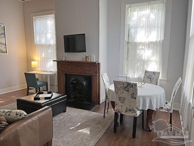 interior space with a fireplace with flush hearth, wood finished floors, and baseboards