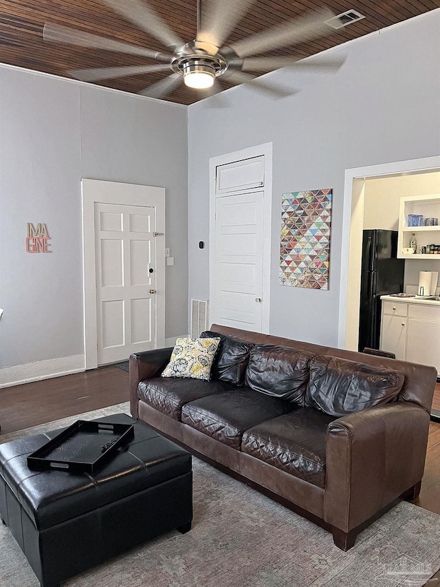 living area featuring a ceiling fan, visible vents, and wood finished floors