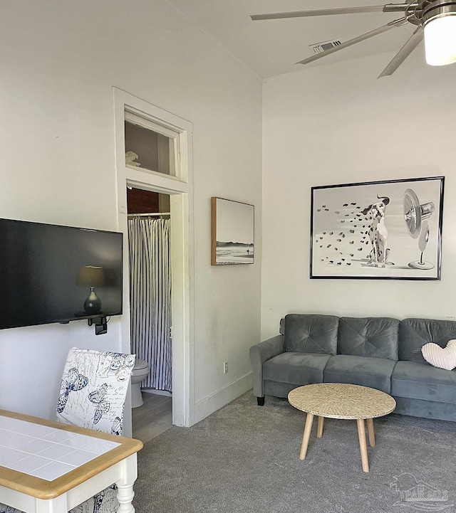 carpeted living room with visible vents and a ceiling fan