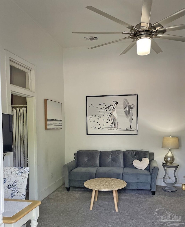 living room with baseboards, carpet, visible vents, and a ceiling fan