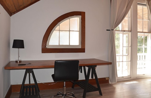 office with lofted ceiling, a healthy amount of sunlight, and wood finished floors