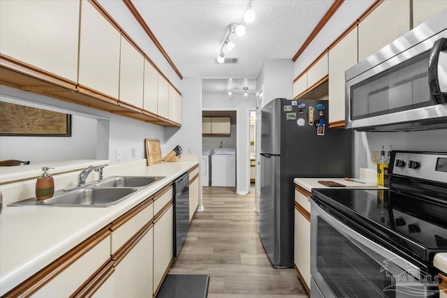 kitchen with washer and dryer, appliances with stainless steel finishes, a textured ceiling, and white cabinetry