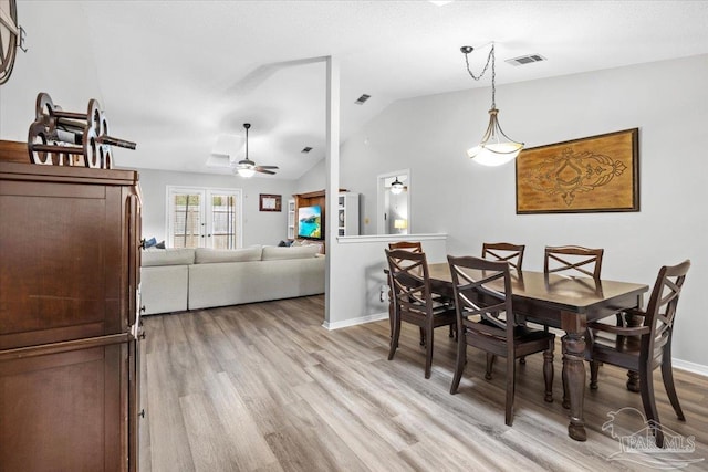 dining area featuring french doors, ceiling fan, light hardwood / wood-style flooring, and vaulted ceiling