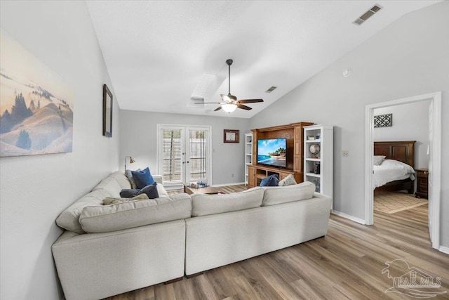 living room with hardwood / wood-style flooring, ceiling fan, and vaulted ceiling