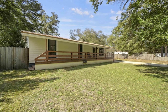 back of property with a lawn and fence