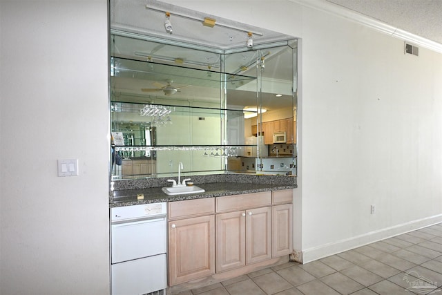 bar with sink, a textured ceiling, light brown cabinetry, light tile patterned flooring, and ornamental molding