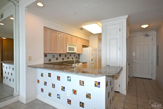 kitchen featuring kitchen peninsula, a textured ceiling, white appliances, and dark stone counters