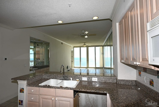 kitchen with crown molding, sink, decorative backsplash, a textured ceiling, and kitchen peninsula