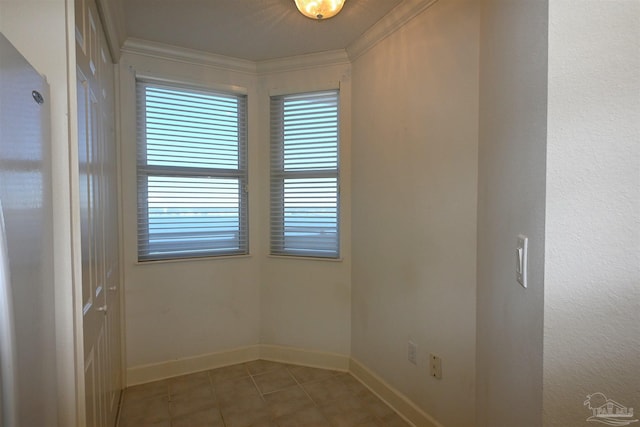 empty room with tile patterned floors and crown molding