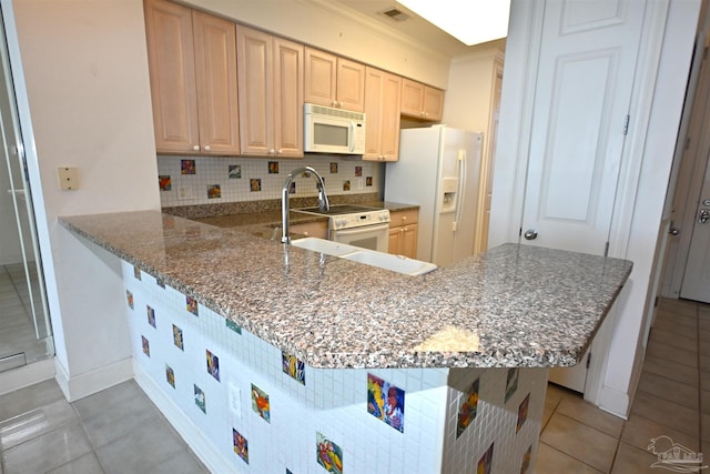 kitchen with light brown cabinets, white appliances, backsplash, stone counters, and kitchen peninsula