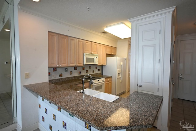 kitchen featuring white appliances, kitchen peninsula, a textured ceiling, and tasteful backsplash