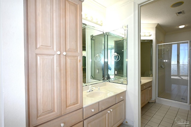 bathroom featuring tile patterned floors, crown molding, a textured ceiling, an enclosed shower, and vanity