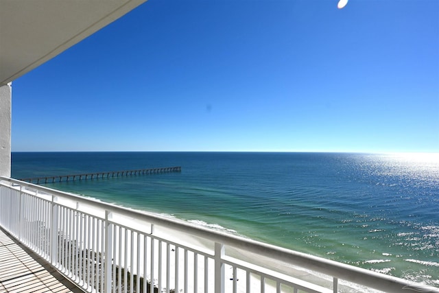 balcony featuring a beach view and a water view