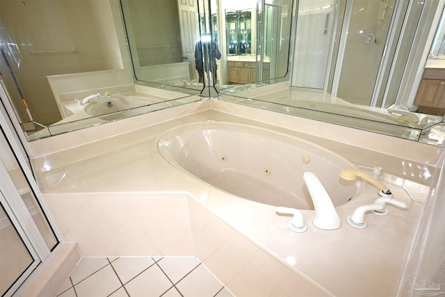 bathroom with tiled bath, tile patterned flooring, and vanity