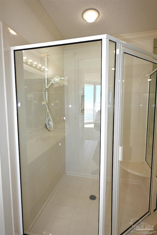 bathroom with tile patterned floors, an enclosed shower, and a textured ceiling