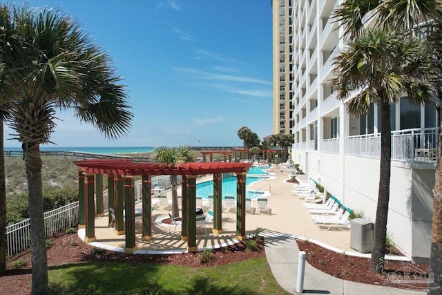 exterior space with a pergola, a water view, a patio, and a pool