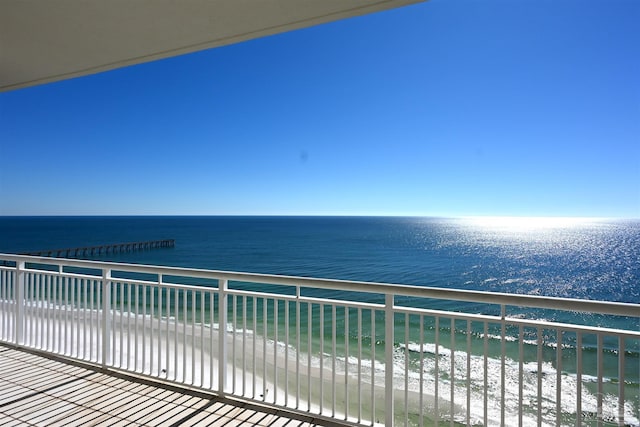 balcony featuring a water view and a beach view