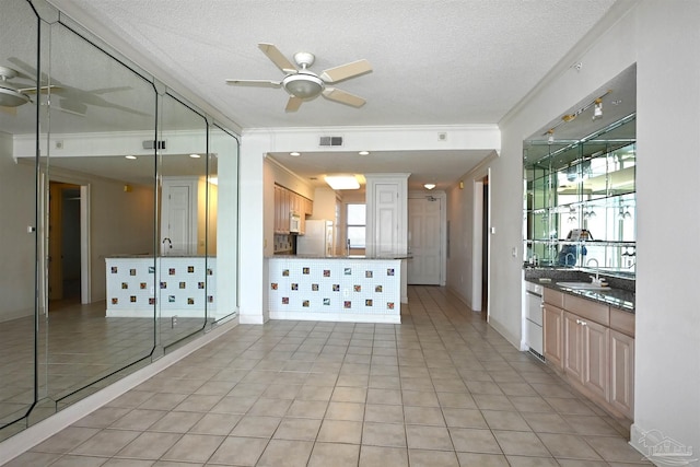 kitchen with sink, plenty of natural light, a textured ceiling, and white appliances