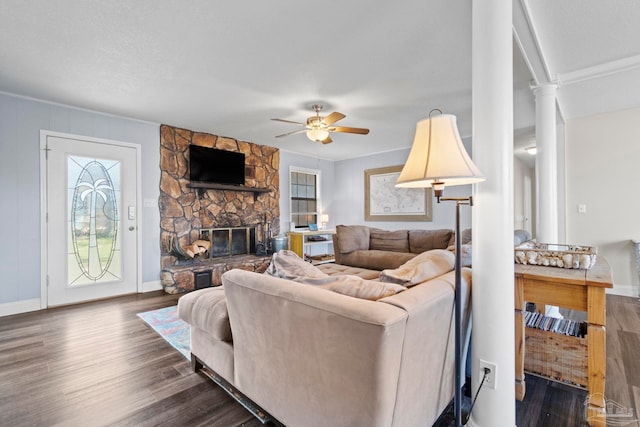 living room with a fireplace, dark wood-type flooring, decorative columns, and ceiling fan