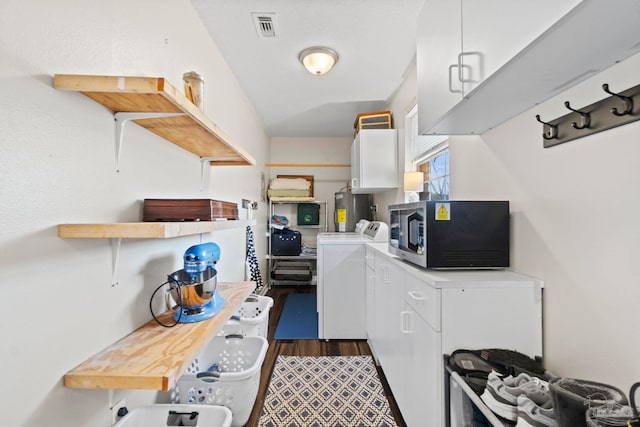 clothes washing area featuring water heater and washing machine and dryer