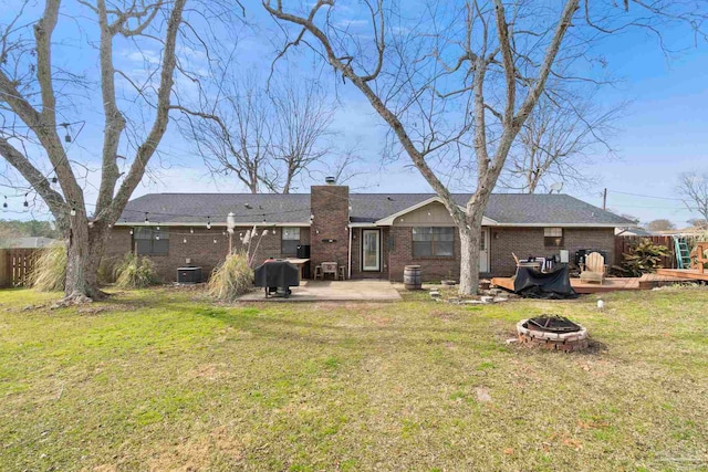 back of house featuring a patio, a lawn, and an outdoor fire pit