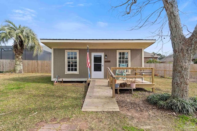 view of front of house with an outdoor structure and a front lawn