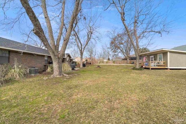 view of yard with central AC and a deck