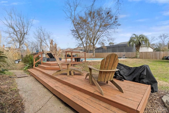 wooden terrace with a fenced in pool and a lawn