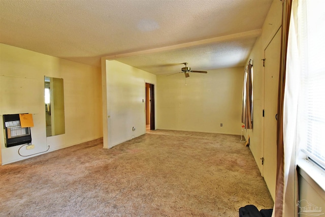 carpeted spare room featuring a textured ceiling, heating unit, and ceiling fan