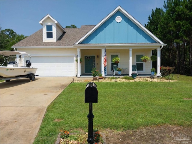 view of front of house featuring covered porch, a front lawn, and a garage