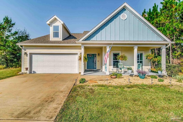 view of front of house with a porch, a front lawn, and a garage