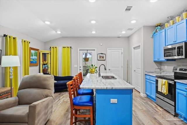 138 Georgia St, Crestview, FL 32536 - kitchen featuring stainless steel appliances, a sink, blue cabinetry, open floor plan, and vaulted ceiling