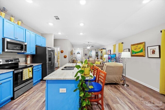 138 Georgia St, Crestview, FL 32536 - kitchen with appliances with stainless steel finishes, a sink, blue cabinets, light wood-style floors, and recessed lighting