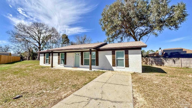 ranch-style house featuring a patio area, a front yard, fence, and brick siding