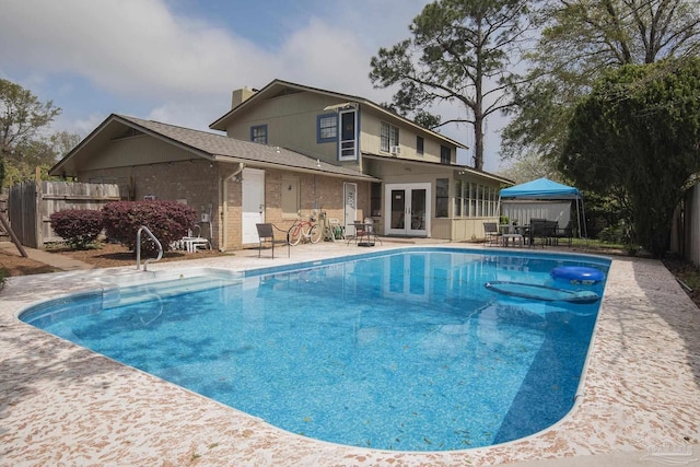 view of swimming pool featuring french doors and a patio area