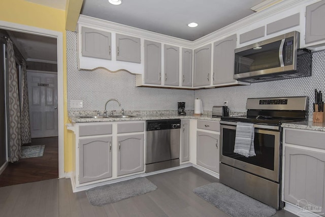 kitchen featuring sink, crown molding, dark wood-type flooring, stainless steel appliances, and white cabinets