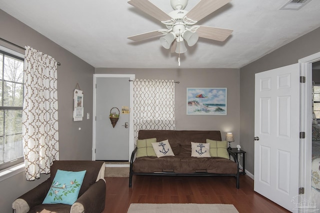 living room featuring dark wood-type flooring and ceiling fan