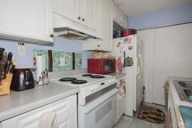 kitchen featuring a textured ceiling, light tile patterned floors, white cabinets, and white appliances