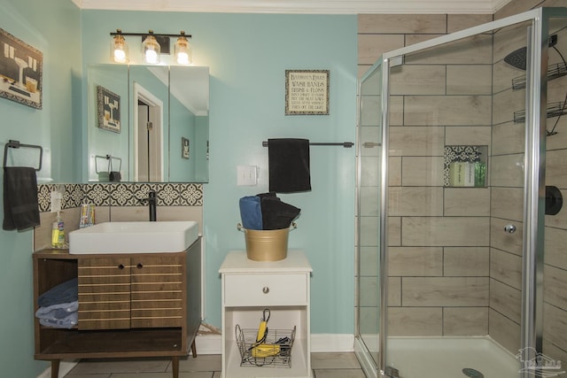 bathroom with tile patterned floors, crown molding, vanity, a shower with door, and backsplash