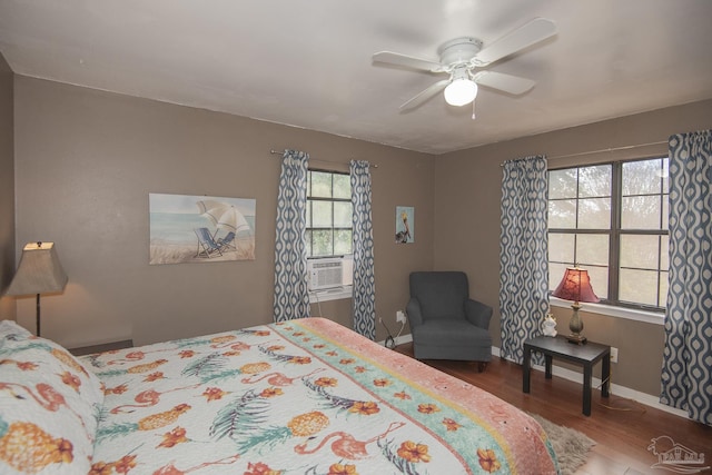 bedroom with cooling unit, hardwood / wood-style floors, and ceiling fan