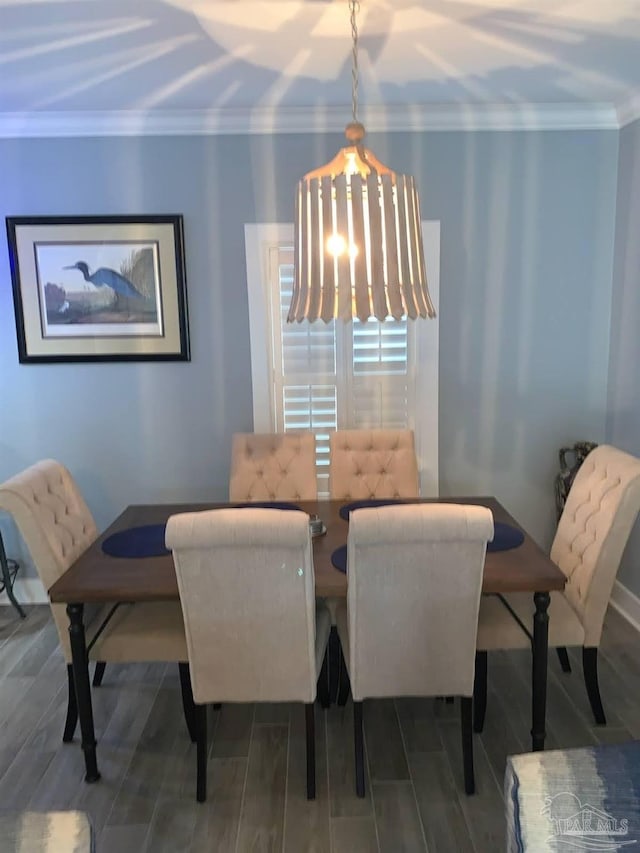 dining area with a chandelier, hardwood / wood-style floors, and crown molding