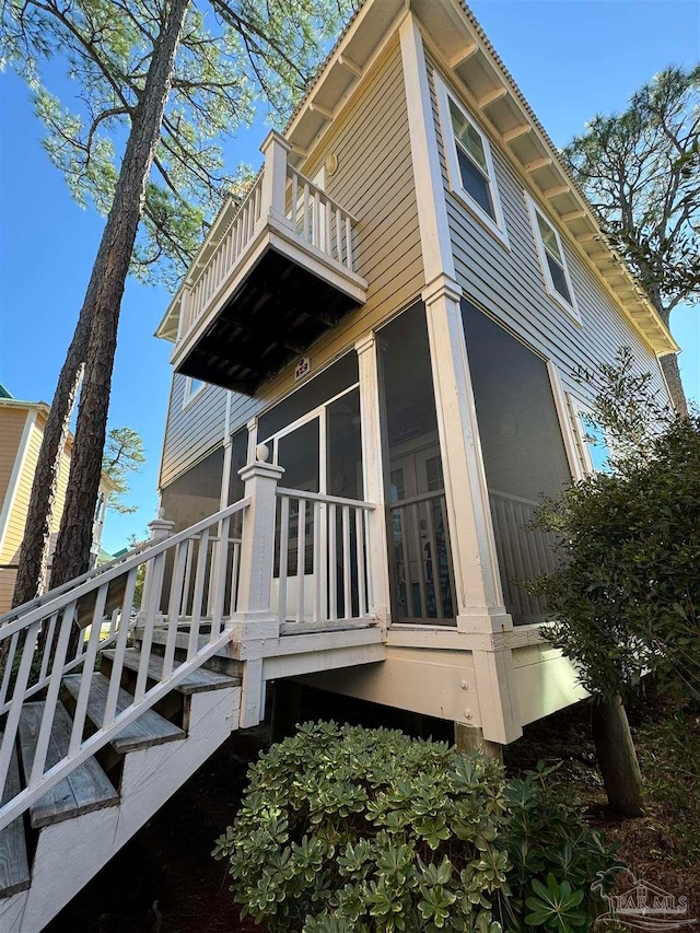 view of home's exterior featuring a sunroom and a balcony