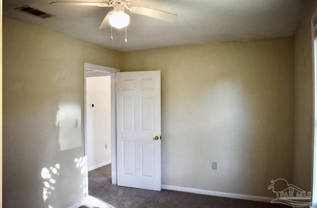 unfurnished room featuring ceiling fan and dark carpet