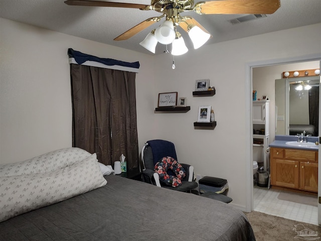 carpeted bedroom featuring a textured ceiling, ceiling fan, and sink